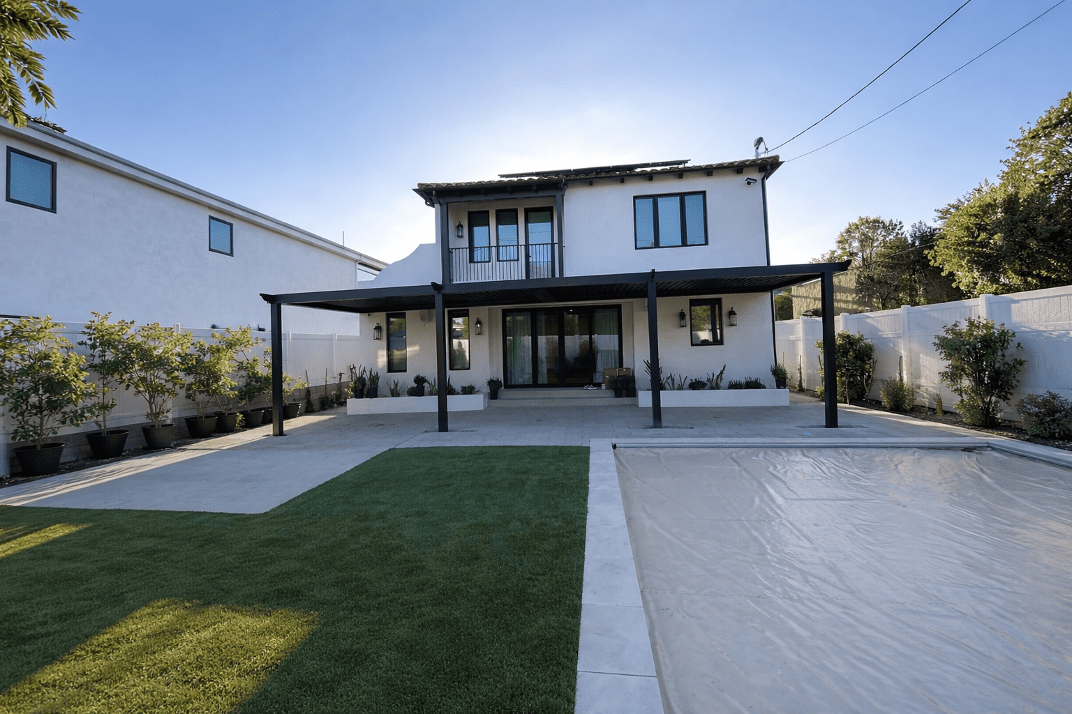 Modern two-story house with a covered patio and a spacious backyard.